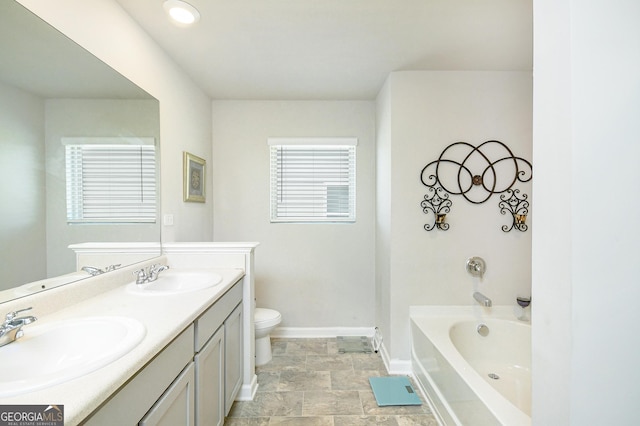 full bath featuring a bath, baseboards, toilet, and a sink