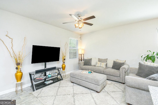 living room with a ceiling fan and baseboards