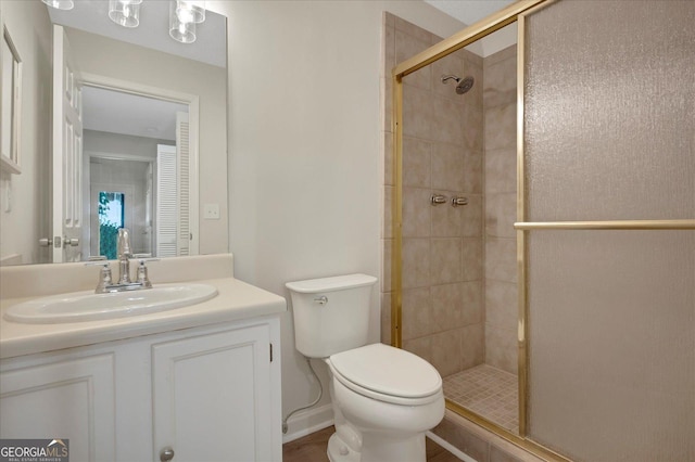 full bathroom featuring toilet, a shower stall, and vanity