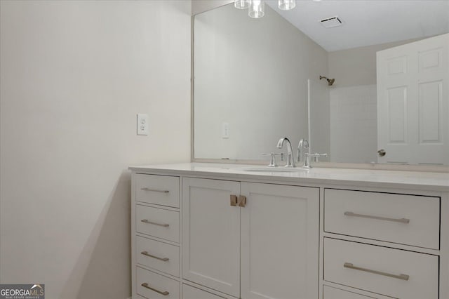 full bathroom featuring visible vents, a shower, and vanity