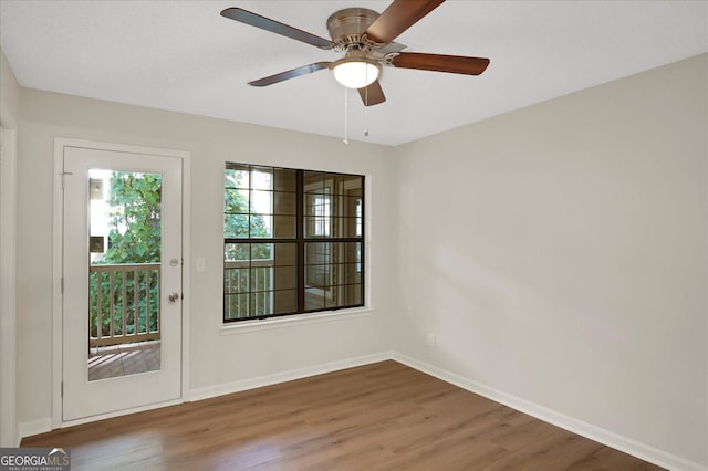 unfurnished room featuring a ceiling fan, baseboards, and wood finished floors