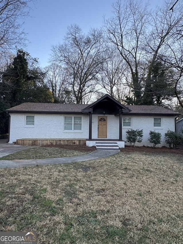 view of front of home featuring a front lawn and brick siding