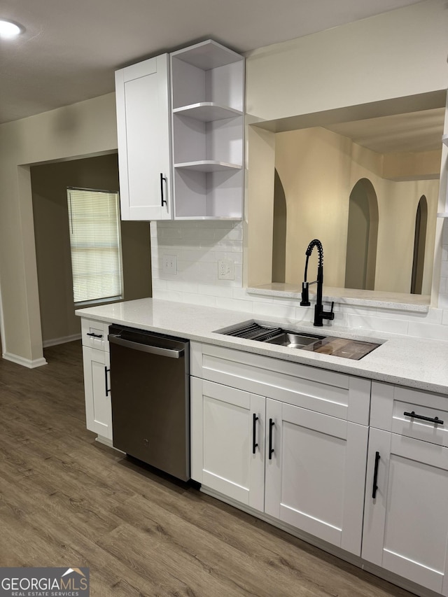 kitchen featuring wood finished floors, a sink, white cabinets, dishwasher, and tasteful backsplash