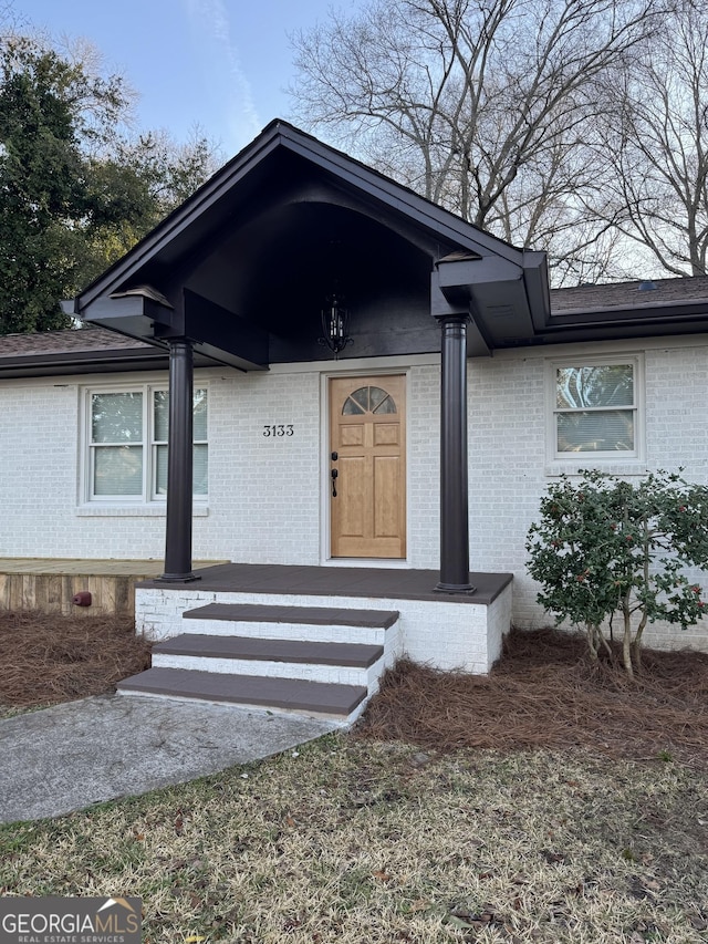 doorway to property featuring brick siding