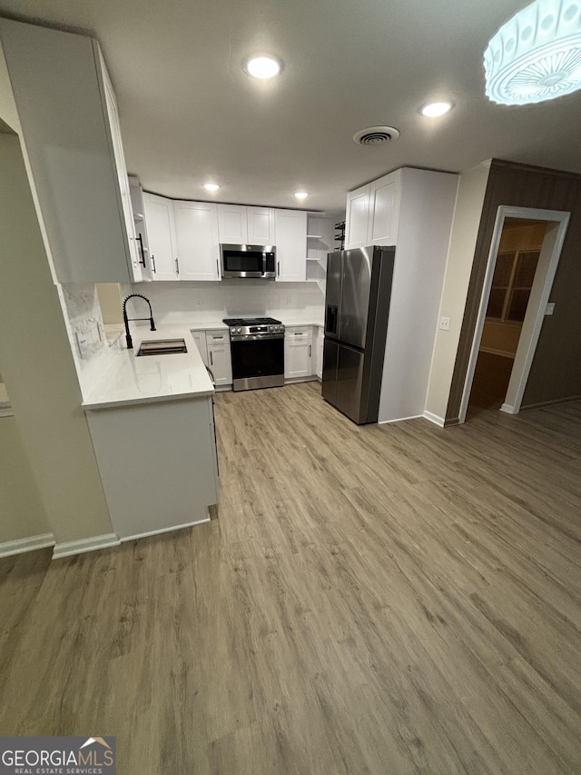 kitchen featuring a sink, visible vents, appliances with stainless steel finishes, open shelves, and light wood finished floors