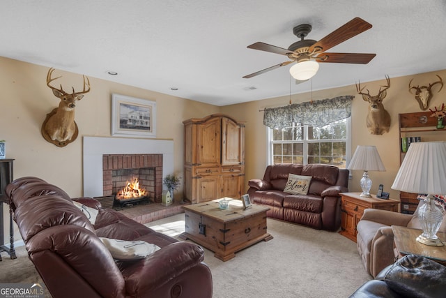 living room with ceiling fan, a fireplace, visible vents, and light colored carpet