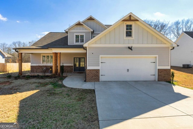 craftsman inspired home with a garage, concrete driveway, brick siding, and french doors