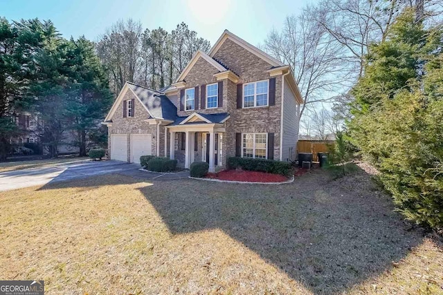 traditional-style house with a garage, brick siding, driveway, and a front lawn