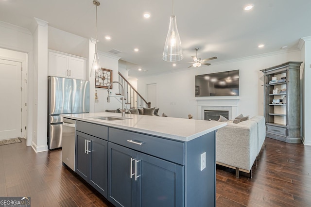 kitchen with a sink, dark wood-style floors, a glass covered fireplace, stainless steel appliances, and crown molding