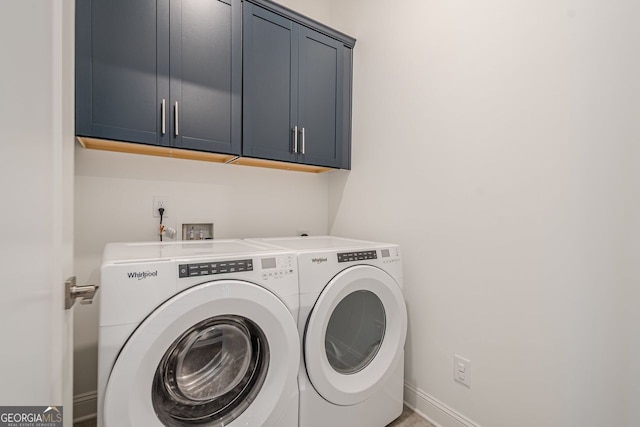 washroom with cabinet space, independent washer and dryer, and baseboards