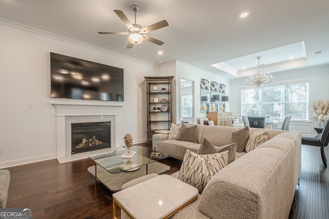 living area with a high end fireplace, crown molding, baseboards, a raised ceiling, and dark wood-style flooring