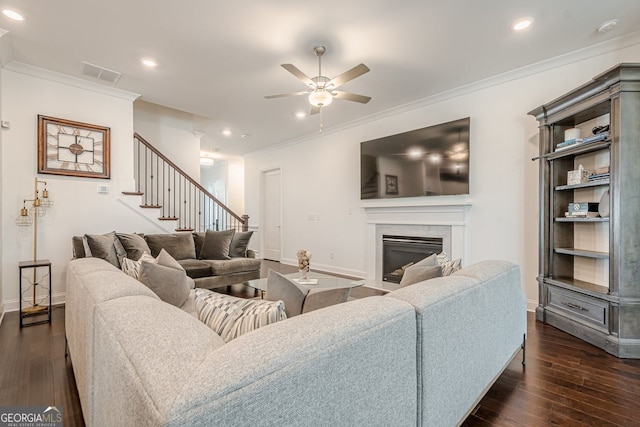 living area featuring dark wood-style floors, visible vents, and ornamental molding