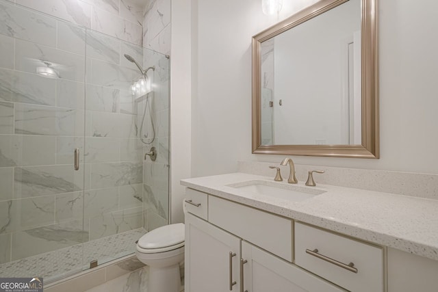 bathroom with vanity, a shower stall, and toilet