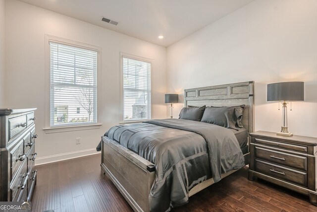 bedroom with dark wood-style floors, visible vents, recessed lighting, and baseboards