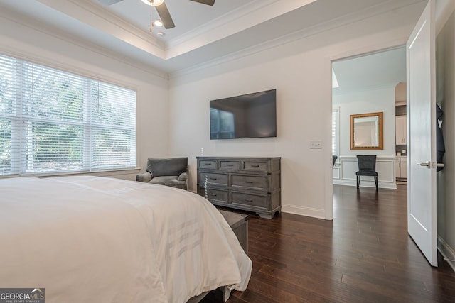 bedroom with a tray ceiling, recessed lighting, crown molding, baseboards, and dark wood-style flooring