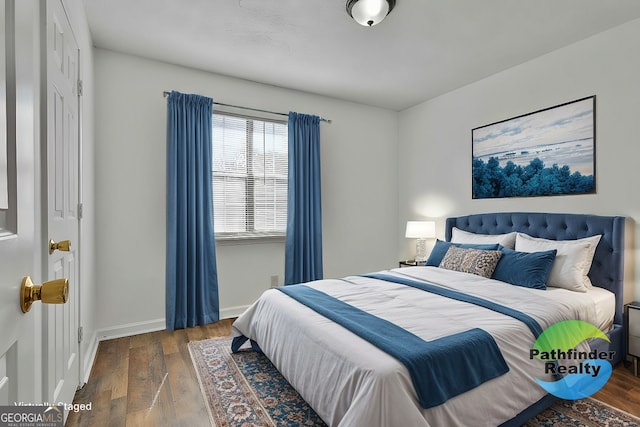 bedroom featuring baseboards and wood finished floors