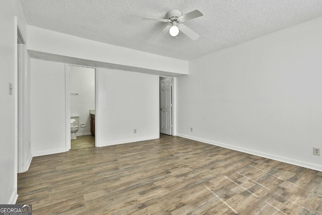 unfurnished bedroom featuring ceiling fan, connected bathroom, a textured ceiling, and wood finished floors