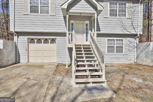 doorway to property with a garage and driveway