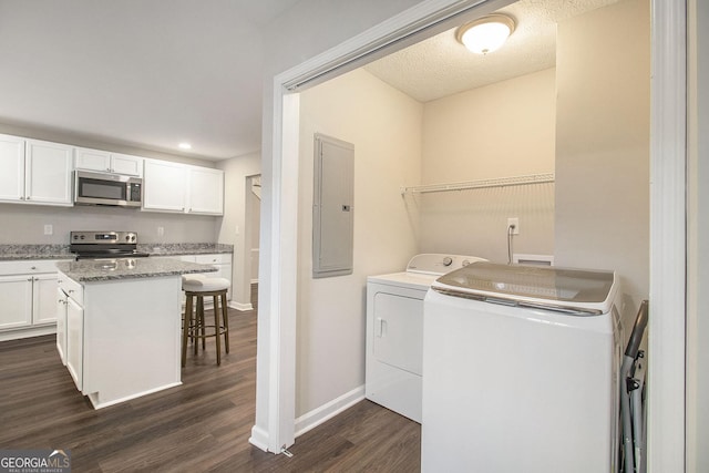 laundry room featuring laundry area, electric panel, baseboards, dark wood finished floors, and washing machine and dryer