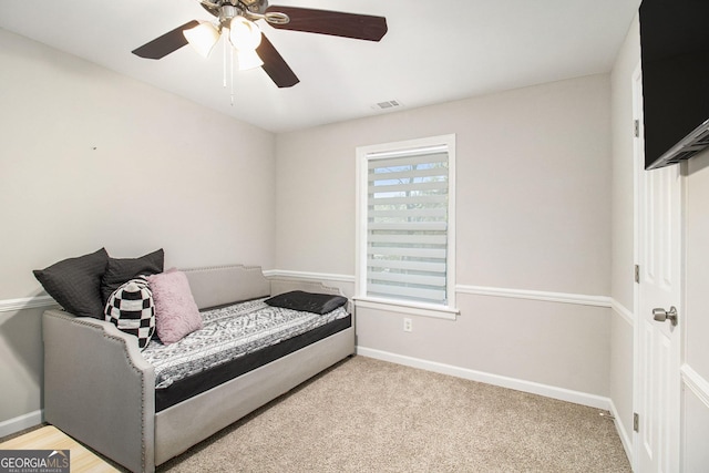 living area with baseboards, visible vents, ceiling fan, and carpet flooring