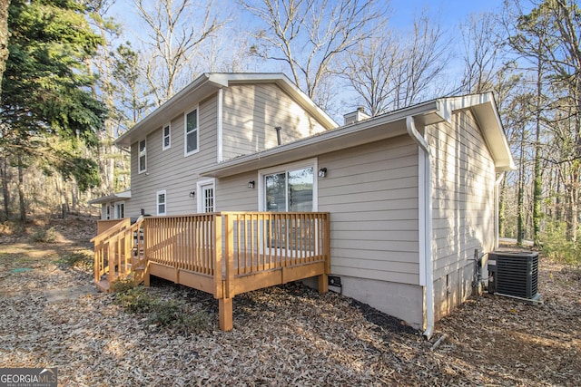 rear view of house featuring a chimney, a deck, and cooling unit