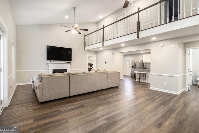 living area with dark wood-style floors, ceiling fan, and a fireplace