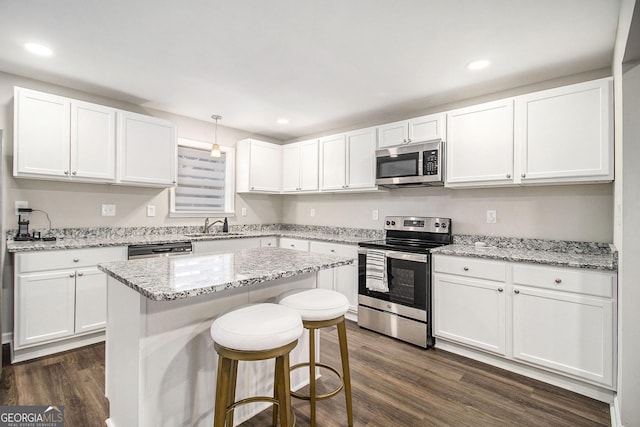 kitchen with dark wood-style floors, appliances with stainless steel finishes, and white cabinetry