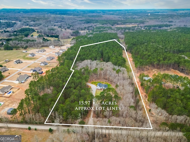 drone / aerial view featuring a wooded view