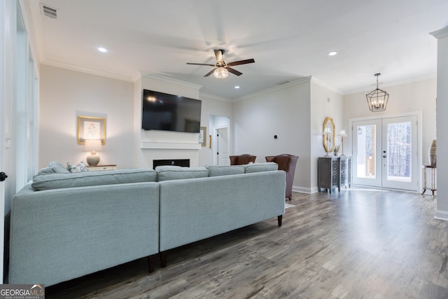 living room featuring a fireplace, wood finished floors, visible vents, baseboards, and french doors