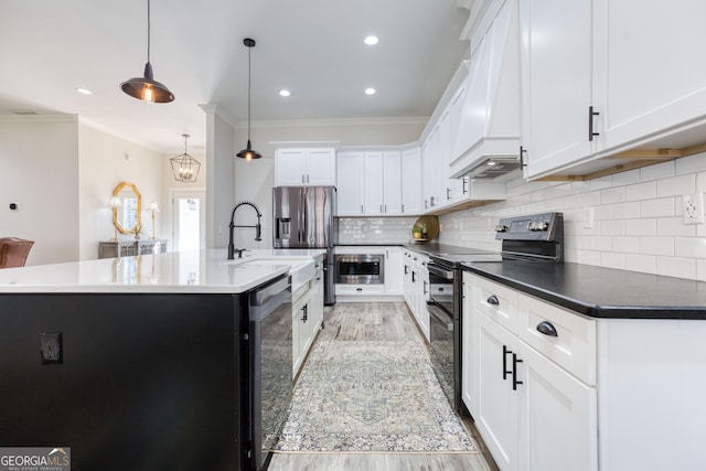 kitchen featuring a center island with sink, range with two ovens, stainless steel fridge with ice dispenser, dishwashing machine, and premium range hood