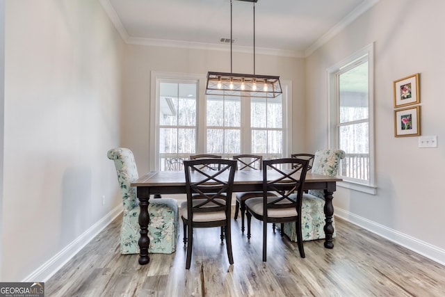 dining area featuring visible vents, baseboards, crown molding, and wood finished floors