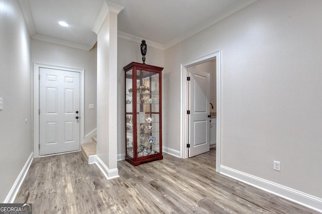 foyer entrance with ornamental molding, recessed lighting, baseboards, and wood finished floors