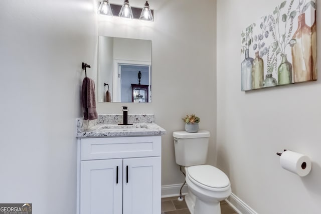 bathroom featuring vanity, toilet, and baseboards