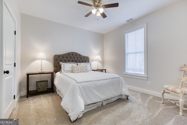 carpeted bedroom featuring baseboards, visible vents, and a ceiling fan