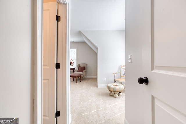 corridor featuring lofted ceiling, carpet, and baseboards