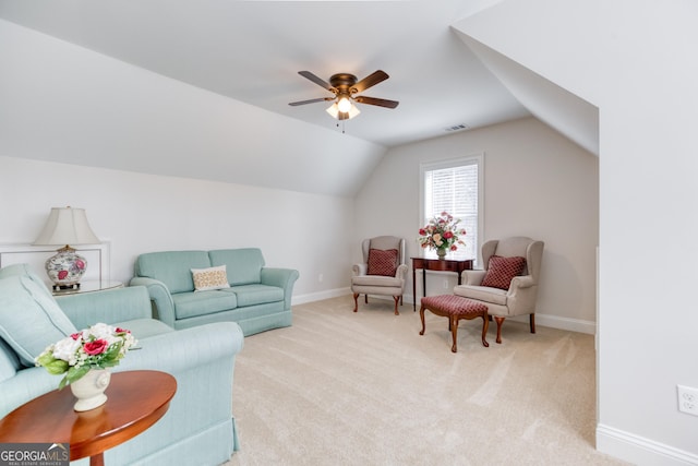 living area with light carpet, lofted ceiling, visible vents, and baseboards