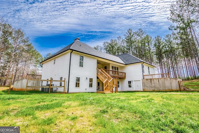 rear view of house with a lawn, ceiling fan, stairway, roof with shingles, and a deck