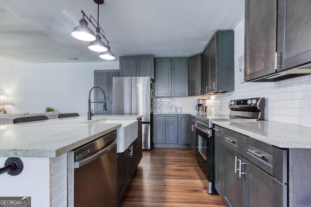 kitchen featuring visible vents, decorative backsplash, dark wood-style floors, decorative light fixtures, and stainless steel appliances