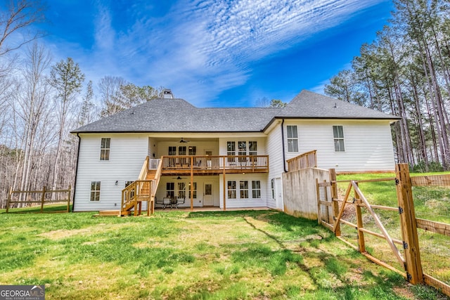 rear view of property featuring a patio, ceiling fan, a lawn, and fence