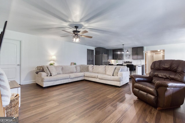 living area featuring ceiling fan and dark wood-style flooring