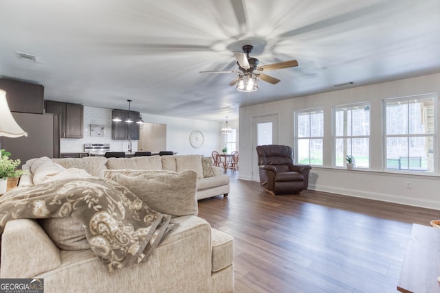 living area with visible vents, dark wood finished floors, and baseboards