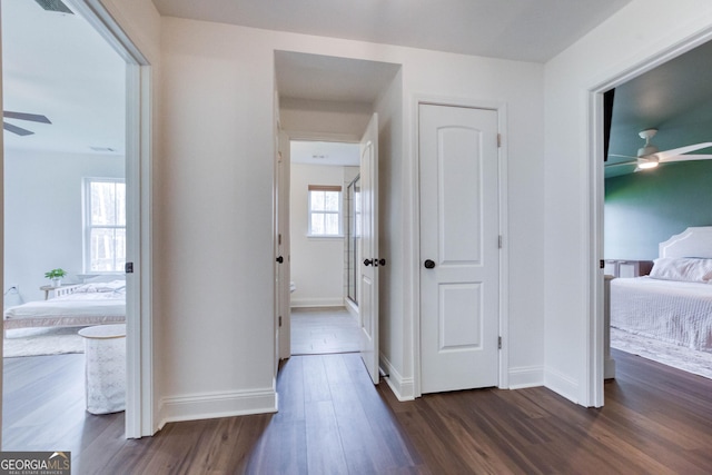 hall with baseboards and dark wood-style flooring