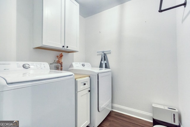 clothes washing area with cabinet space, baseboards, dark wood-type flooring, and washer and dryer