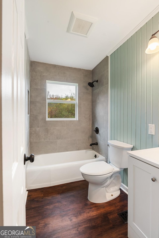 full bath with visible vents, shower / bathing tub combination, toilet, vanity, and wood finished floors