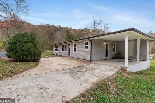 view of front of property featuring an attached carport and driveway