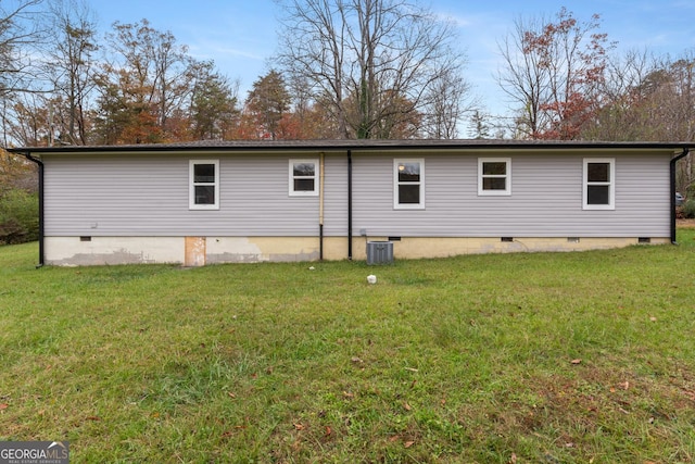 view of side of property featuring cooling unit, crawl space, and a yard