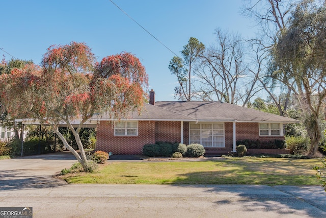 single story home with concrete driveway, brick siding, a chimney, and a front lawn