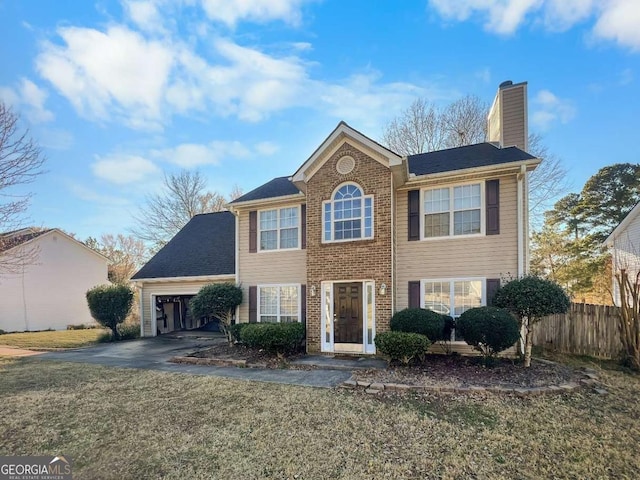 colonial home with a chimney, an attached garage, a front yard, fence, and driveway