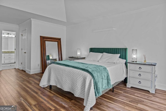 bedroom featuring baseboards, ornamental molding, and wood finished floors