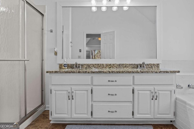 full bathroom featuring a shower with shower door, a sink, a bathing tub, and double vanity